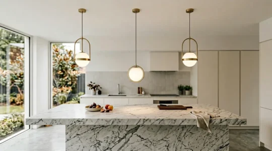 Three contemporary pendant lights illuminating a marble kitchen island with bar stools