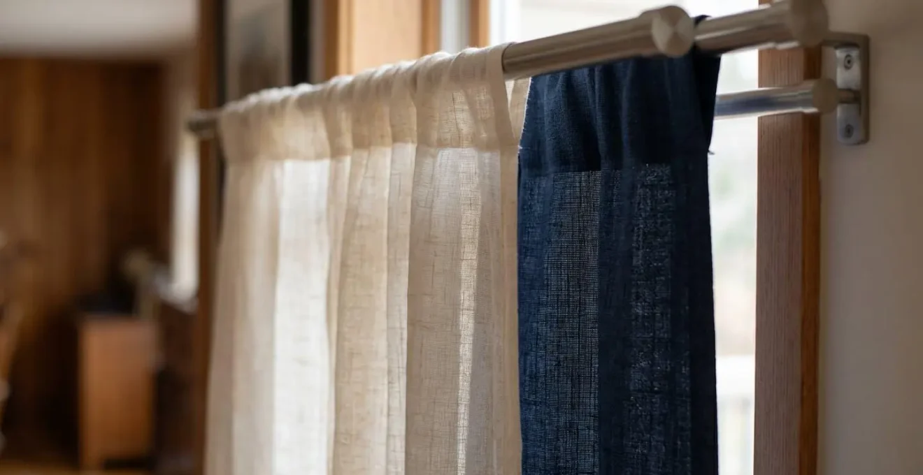 Artistic side-view cross-section of a double rod system, with a light sheer curtain in front and a heavy blackout liner behind.